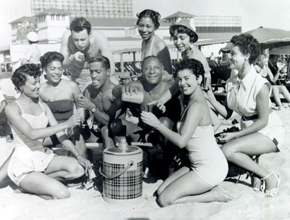 a group of beautiful man and woman in the beach